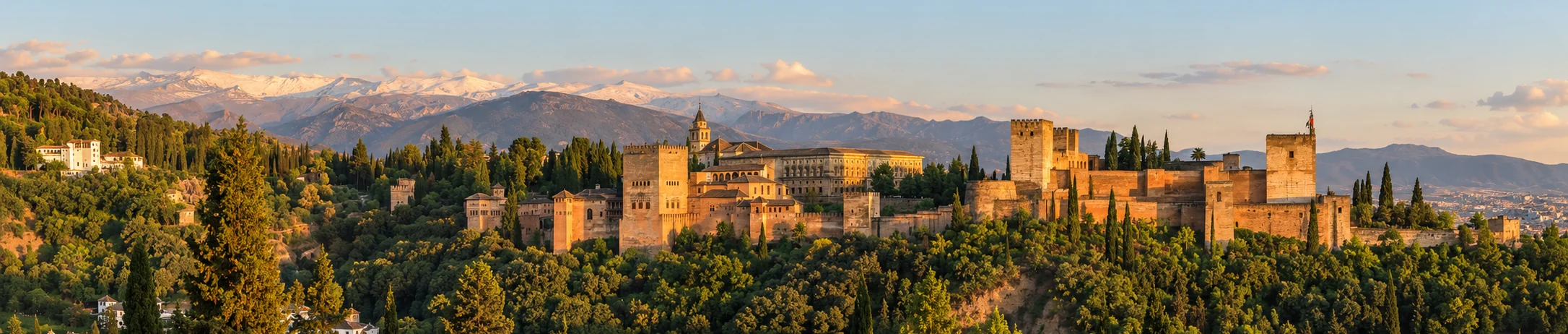 Vista panorámica de la Alhambra de Granada al atardecer con Sierra Nevada al fondo